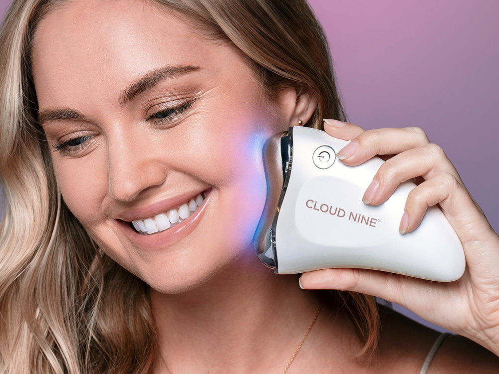 Model using the Revive Beauty Device on her jawline with the blue light setting on.