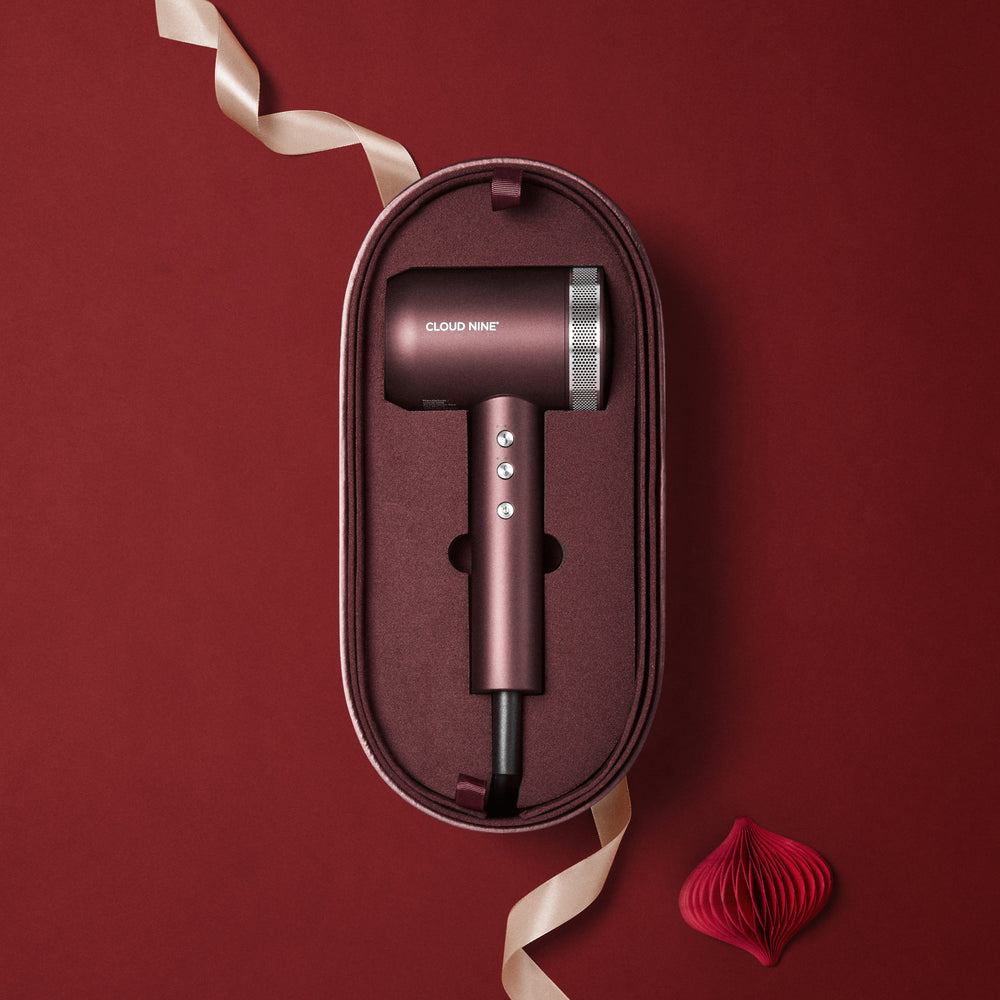 The Dark Burgundy Airshot Pro hair dryer in a matching case on a red background with 'Cloud Nine' branding.