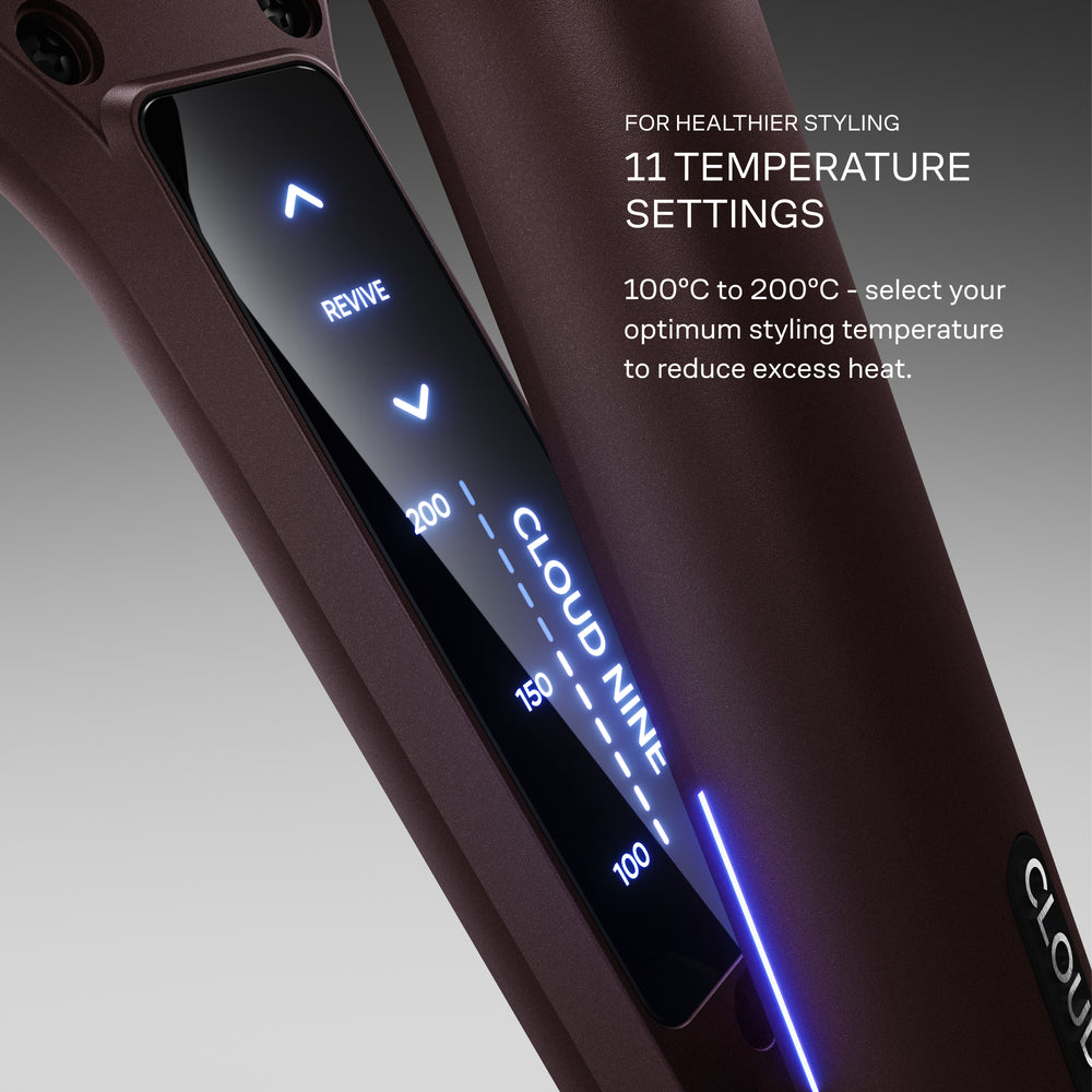 The Wide Iron in Dark Burgundy pictured with a lit up digital display, featuring temperature settings from 100 to 200 degrees celsius on a gradient grey background. Select your optimum styling temperature to reduce excess heat.