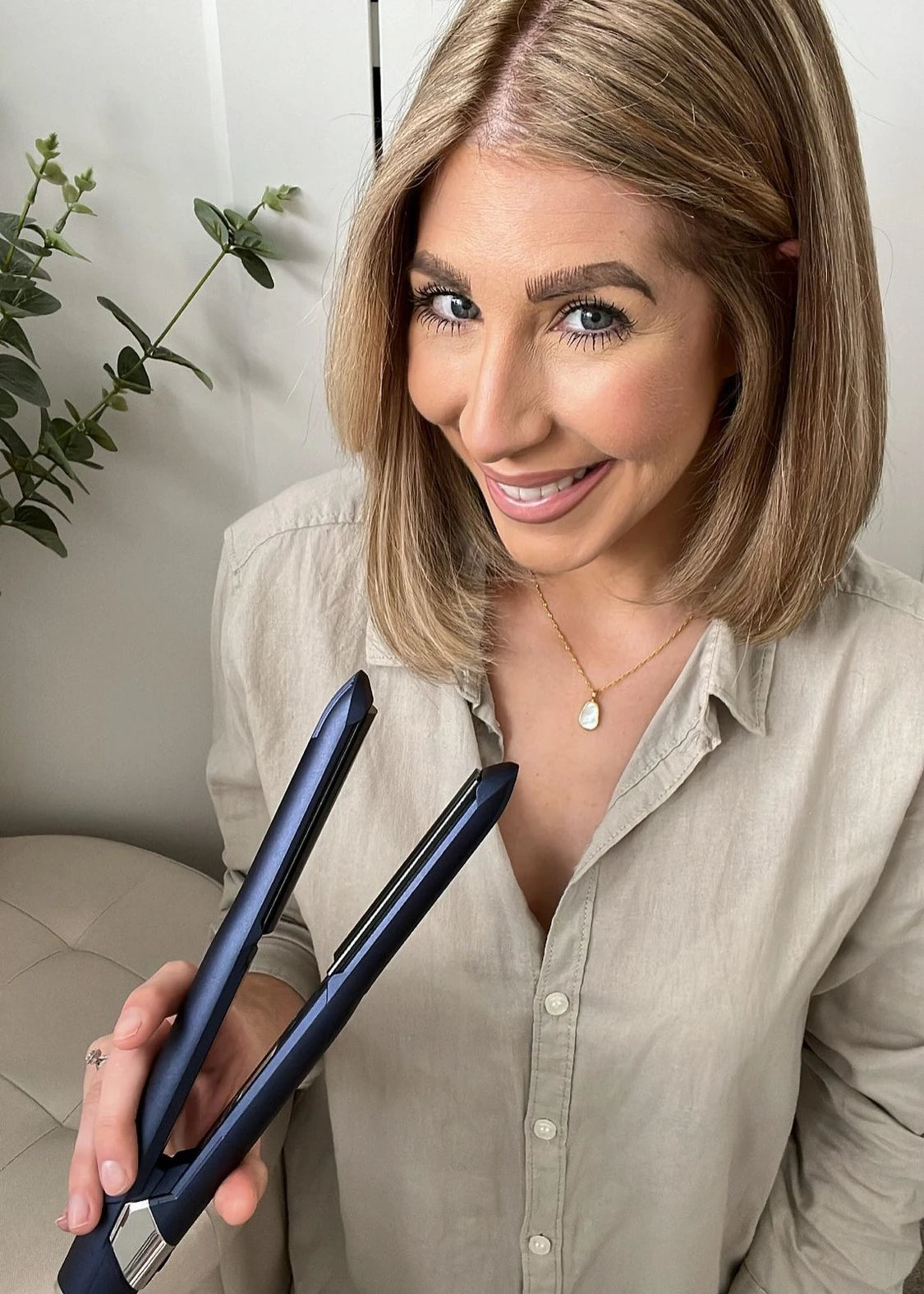 camera shot of female influencer smiling while holding 2-in-1 Contouring Iron Pro up to the camera