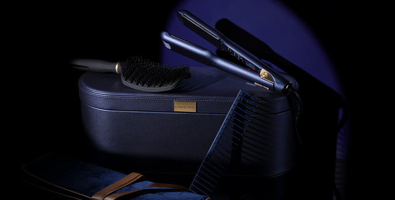 spotlight shot of the blue luxury premium case, the midnight wide iron iron, black curved detangling comb, blue wet comb and blue velvet pouch with gold ribbon