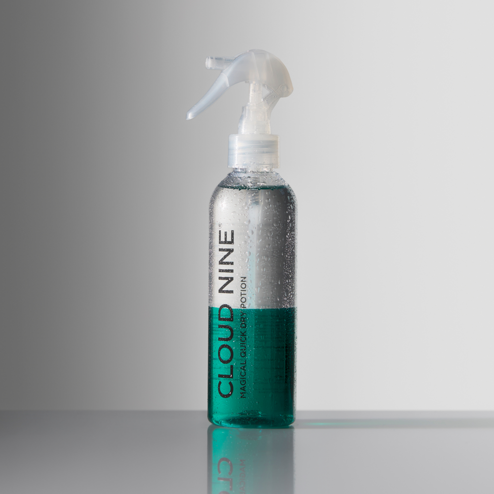 Bottle of the Magical Quick Dry Potion before it has been shaken, with a white nozzle and 'Cloud Nine' branding, displayed on a light grey background.