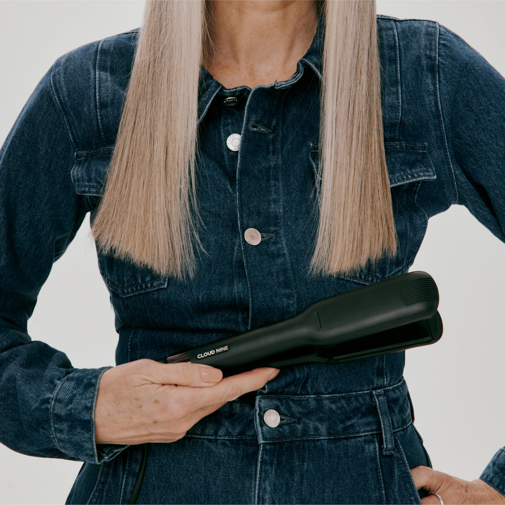 Blonde long-haired model in a blue denim jacket holding the Wide Iron, with plates apart, while showing the 'Cloud Nine' branding.
