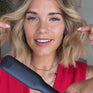 Model showing the Contouring Wide Iron in use on her bob, using the tool to wave hair in sections. 